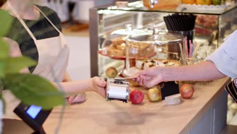 mujer pagando en una cafetería
