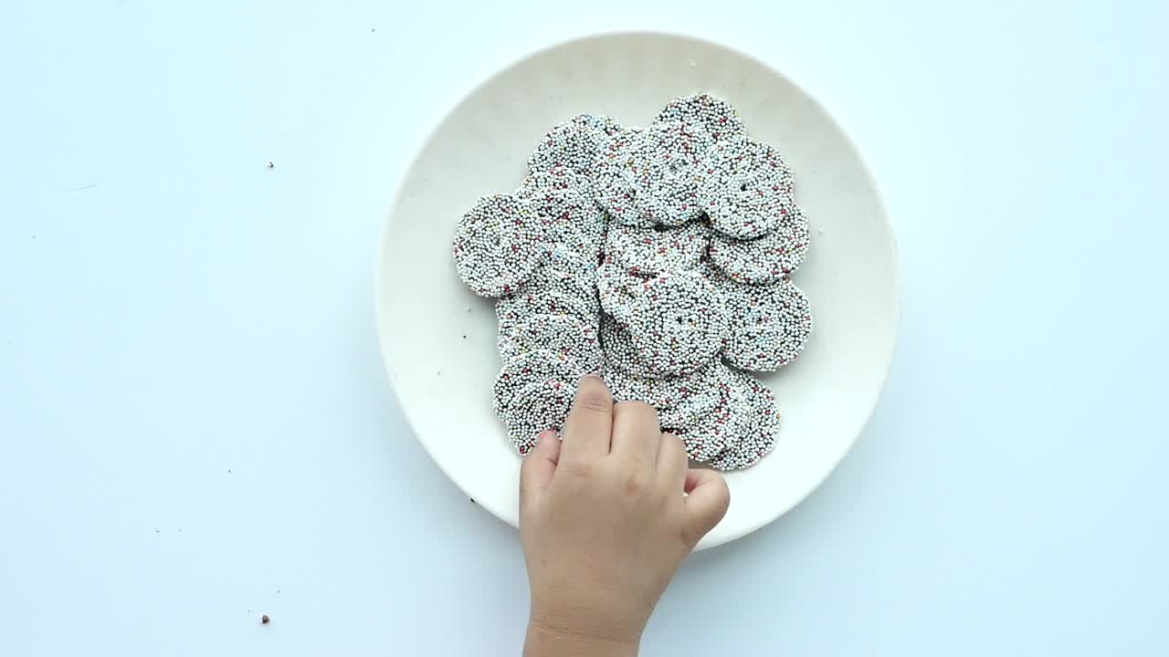 Vista superior de la mano del niño recoger galletas dulces