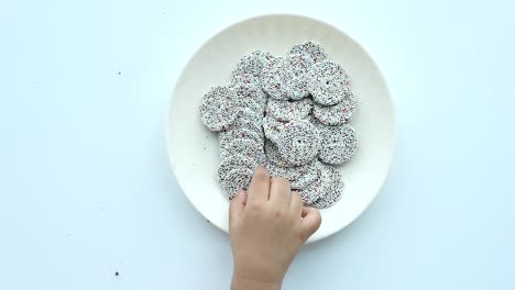 top view of child hand pick sweet cookies