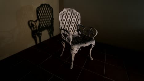 old wrought iron chair casting shadow against wall