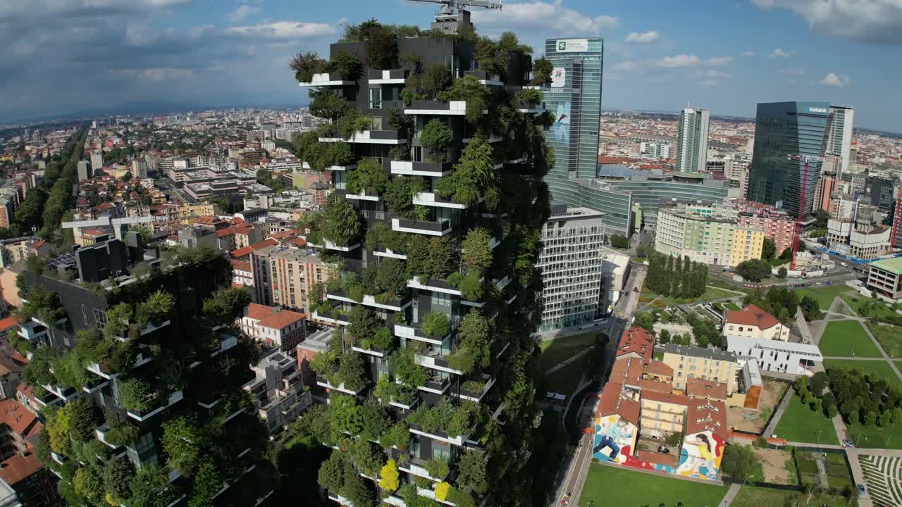 Panoramic drone footage reveals a lively cityscape, with buildings covered in lush greenery and streets weaving through plant-adorned facades and modern urban architecture.