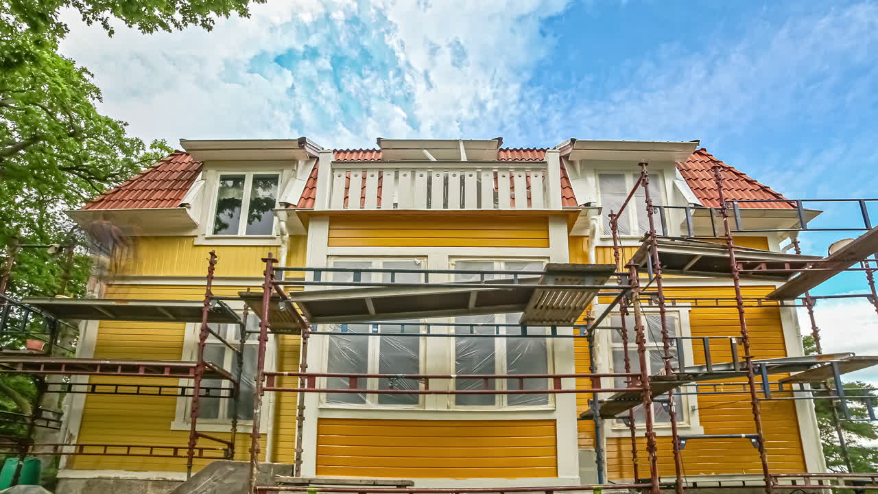 toma en ángulo bajo de hombres reparando las paredes de madera de una casa rural en un lapso de tiempo en un día nublado