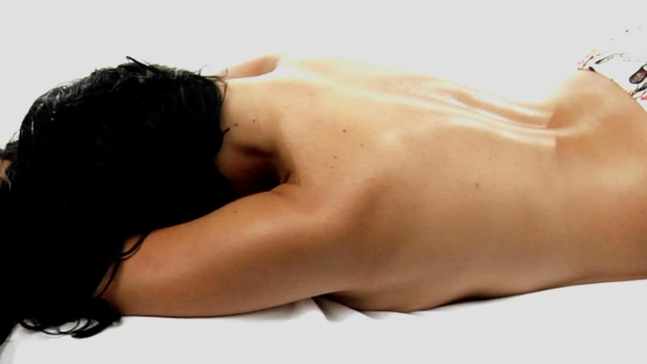 una mujer con bikini y sin top yace boca abajo