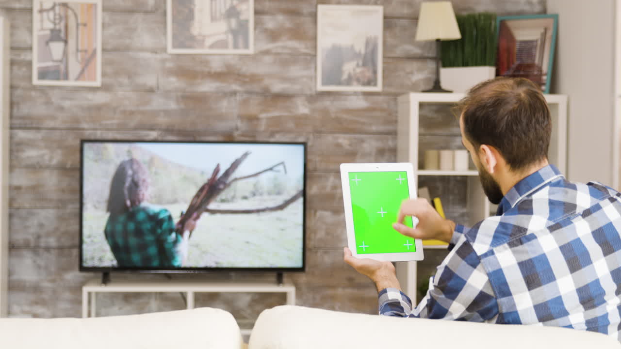 Hombre usando una tableta con pantalla verde en el salón
