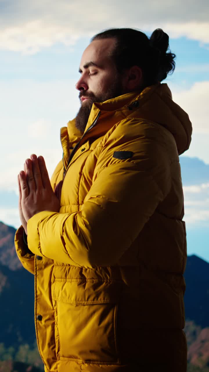 Bearded Man Meditating Outdoors on a Mountain Peak
