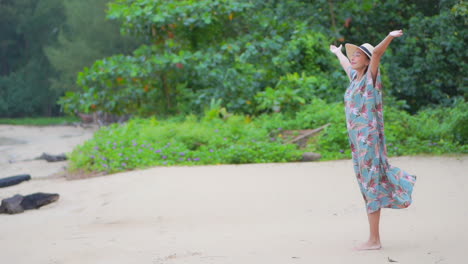 Happy-Exotic-Woman-Walking-on-Sandy-Beach-by-Green-Tropical-Plants-Raising-Hands-Full-of-Joy,-Slow-Motion-Full-Frame