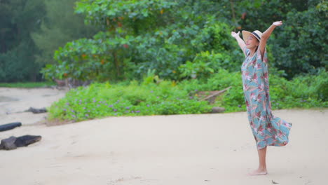 happy exotic woman walking on sandy beach by green tropical plants raising hands full of joy, slow motion full frame