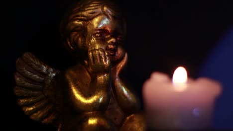 angel figurine looking at the candle