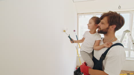 padre e hija pintando una pared juntos