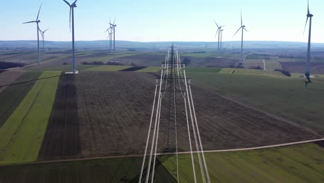 Overhead-Power-Line-Of-Transmission-Tower-In-The-Wind-Farm-With-Wind-Turbines