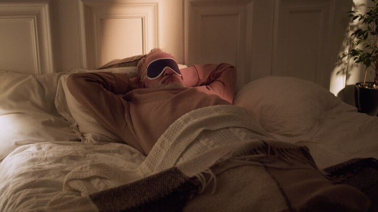 Old man taking off his sleeping mask