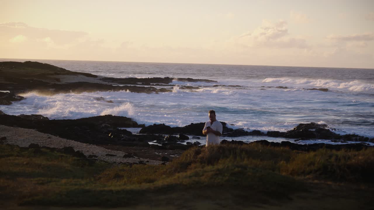 A lone figure stands quietly near the sea, gazing at the rolling waves illuminated by golden sunset light, capturing a moment of solitude, peace, and reflection