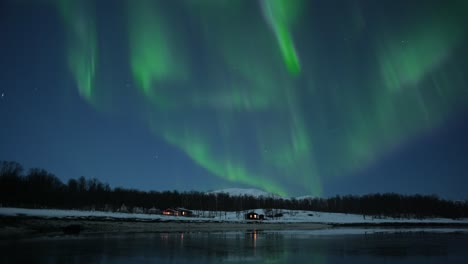 winter scenery with small cozy cabin and northern lights above in the landscape of the arctic northern norway, timelapse, beautiful nature footage