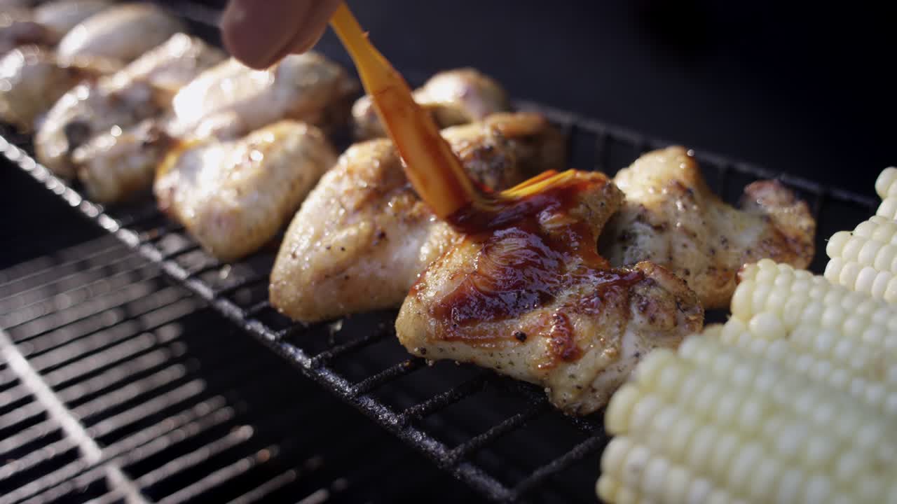 disparo en cámara lenta de salsa de bbq siendo cepillado en pollo a la parrilla fumando