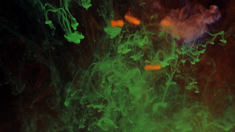 mezclando partículas de colores brillantes de pintura verde y roja en el humo.
