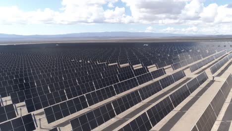 solar panels in vaca muerta, patagonia under a vast cloudy sky