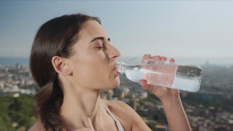 Frau-öffnet-Flasche-Mit-Wasser.-Mädchen-Trinkt-Wasser-Nach-Dem-Yoga-Training-Draußen