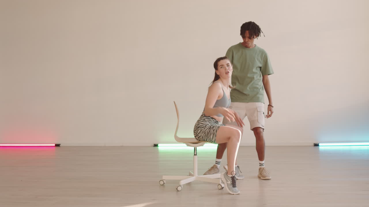 Man Dancing by Woman on Chair