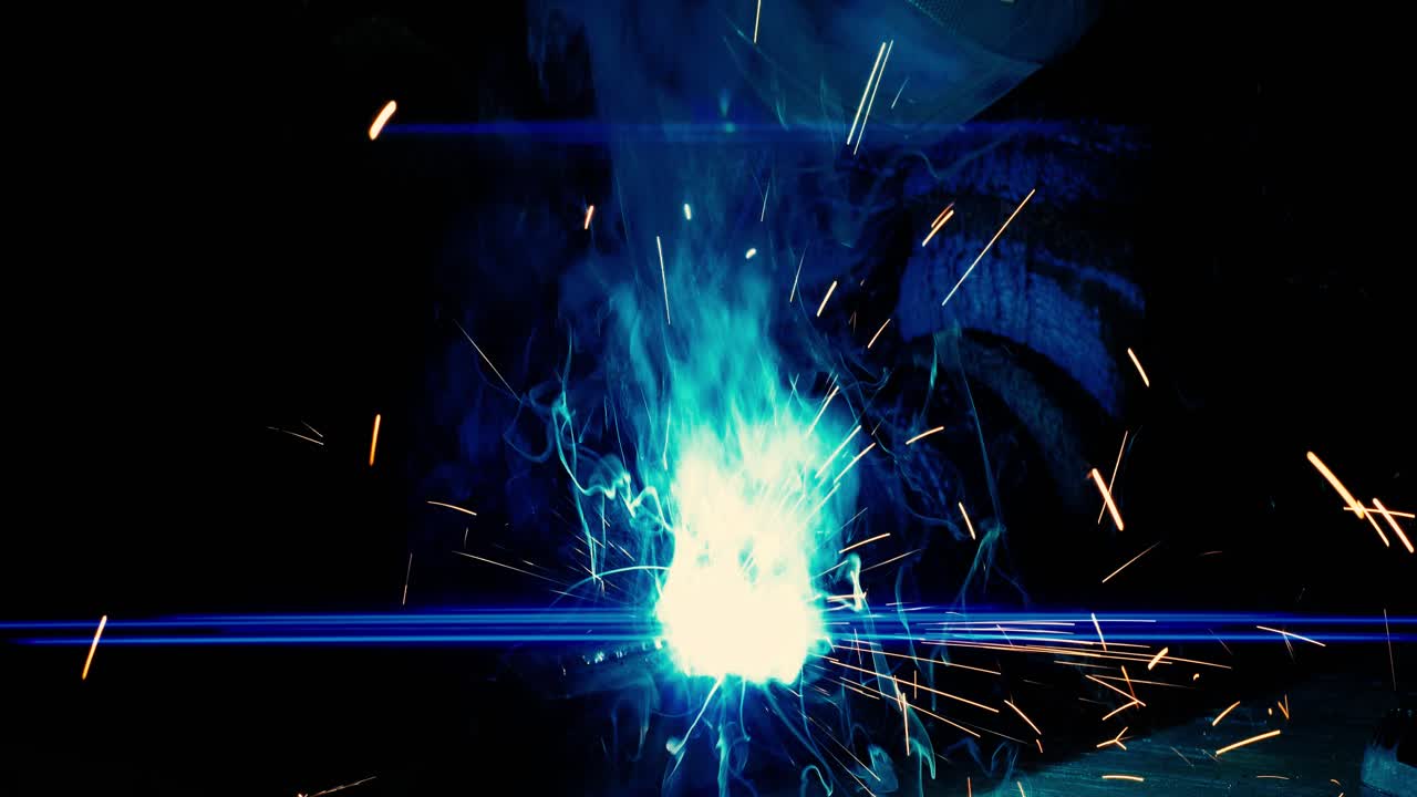 Metal welder works with a steel welder in a factory with protective equipment