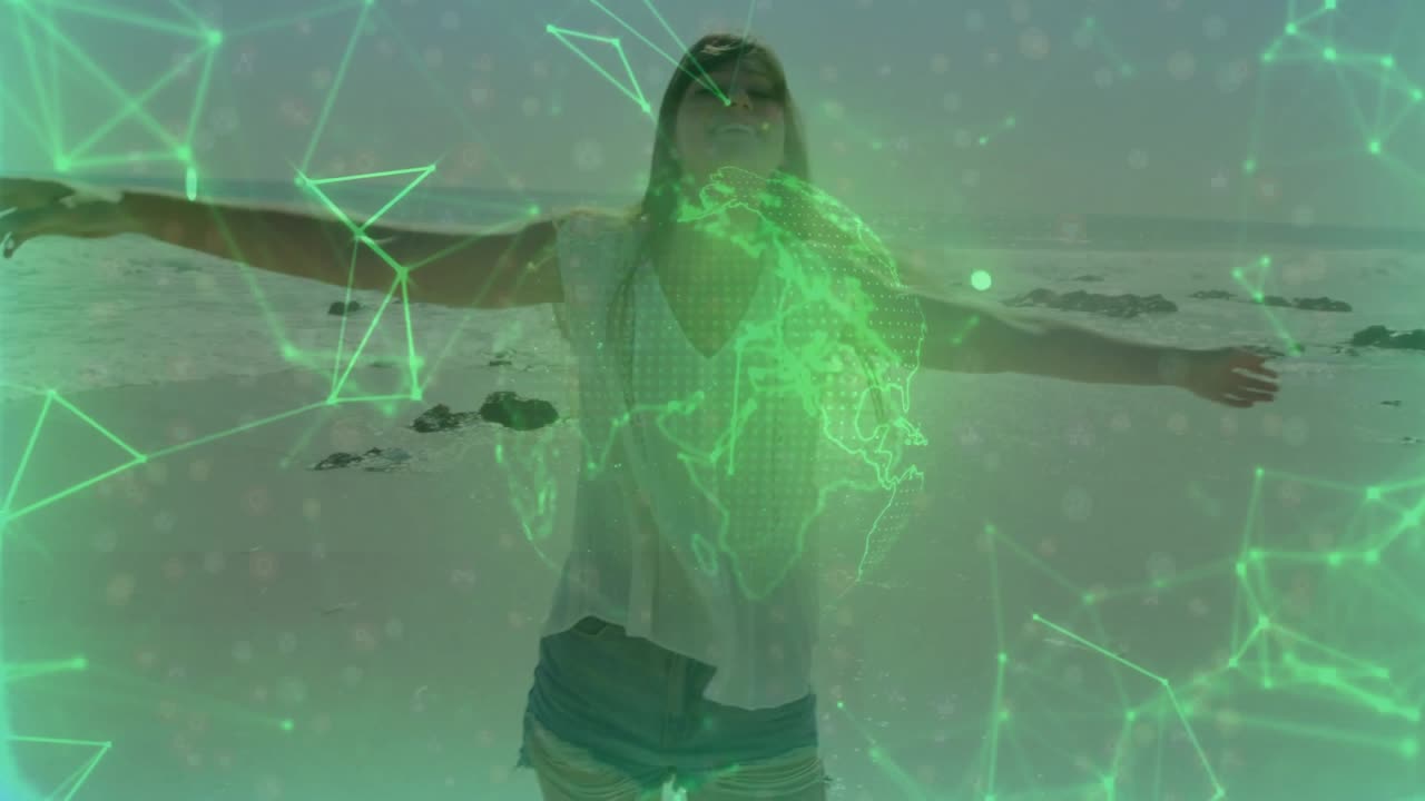 Mujer de pie en la playa activando tecnología verde que muestra una superposición de globo y una red mientras rota los brazos