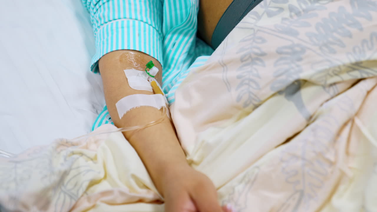 Female hand with connected wire from drop counter. Patient having infusion in hospital ward. Close up.