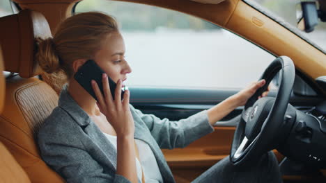 vista lateral de mulher usando telefone no veículo. mulher de negócios sentada em um carro de luxo
