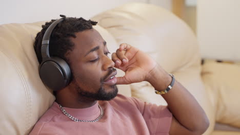 man relaxing on a couch with headphones