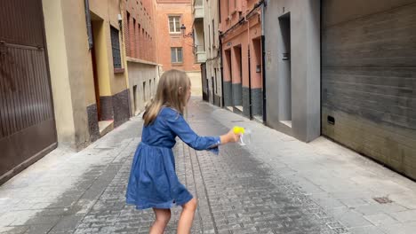 girl playing with soap bubbles in the street