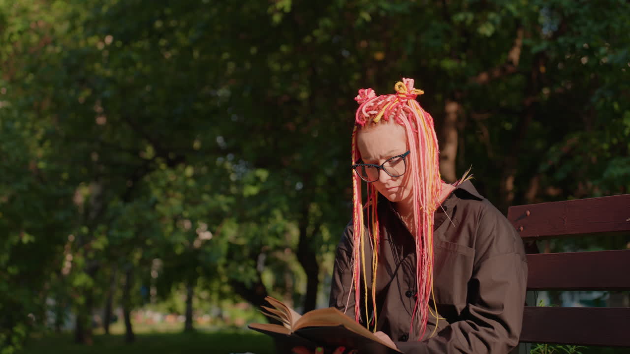 gente disfrutando de los libros al aire libre, varias personas absortas en los libros en un entorno de parque natural, varias personas dedicadas a la lectura en un entorno tranquilo al aire libre en un parque