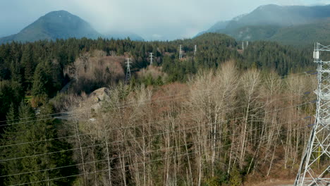 A-power-corridor-cuts-through-a-mountain-wilderness,-but-nature-prevails-as-a-rainbow-peeks-out-over-the-mist-shrouded-valley