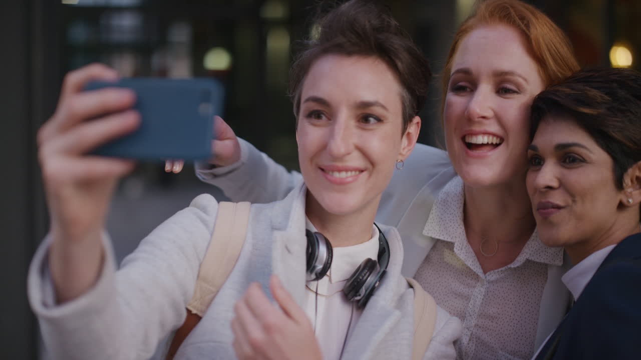 retrato joven grupo multiétnico de mujeres amigas tomando una foto selfie usando un teléfono inteligente disfrutando de un estilo de vida urbano feliz amistad en la ciudad relajada colegas femeninas divirtiéndose en cámara lenta