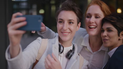 portrait young multi ethnic group of women friends taking selfie photo using smartphone enjoying happy urban lifestyle friendship in city relaxed female colleagues having fun slow motion