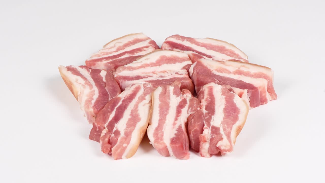 Raw bacon, isolated on white. Side view. Loop motion. Rotation 360.