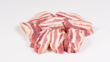 raw bacon, isolated on white. side view. loop motion. rotation 360.