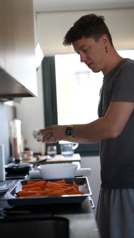 joven cocinando zanahorias en la cocina