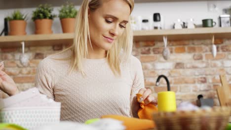 tilt up video of woman sews in the kitchen