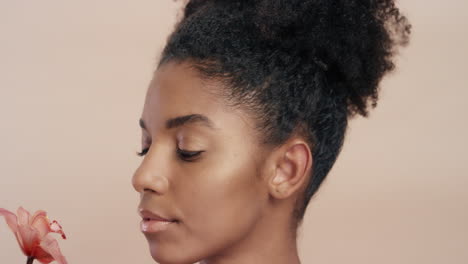 retrato de belleza hermosa mujer afroamericana posando juguetonamente con una flor de orquídea tocando una piel sana disfrutando de la suave fragancia de la esencia natural concepto de cuidado de la piel