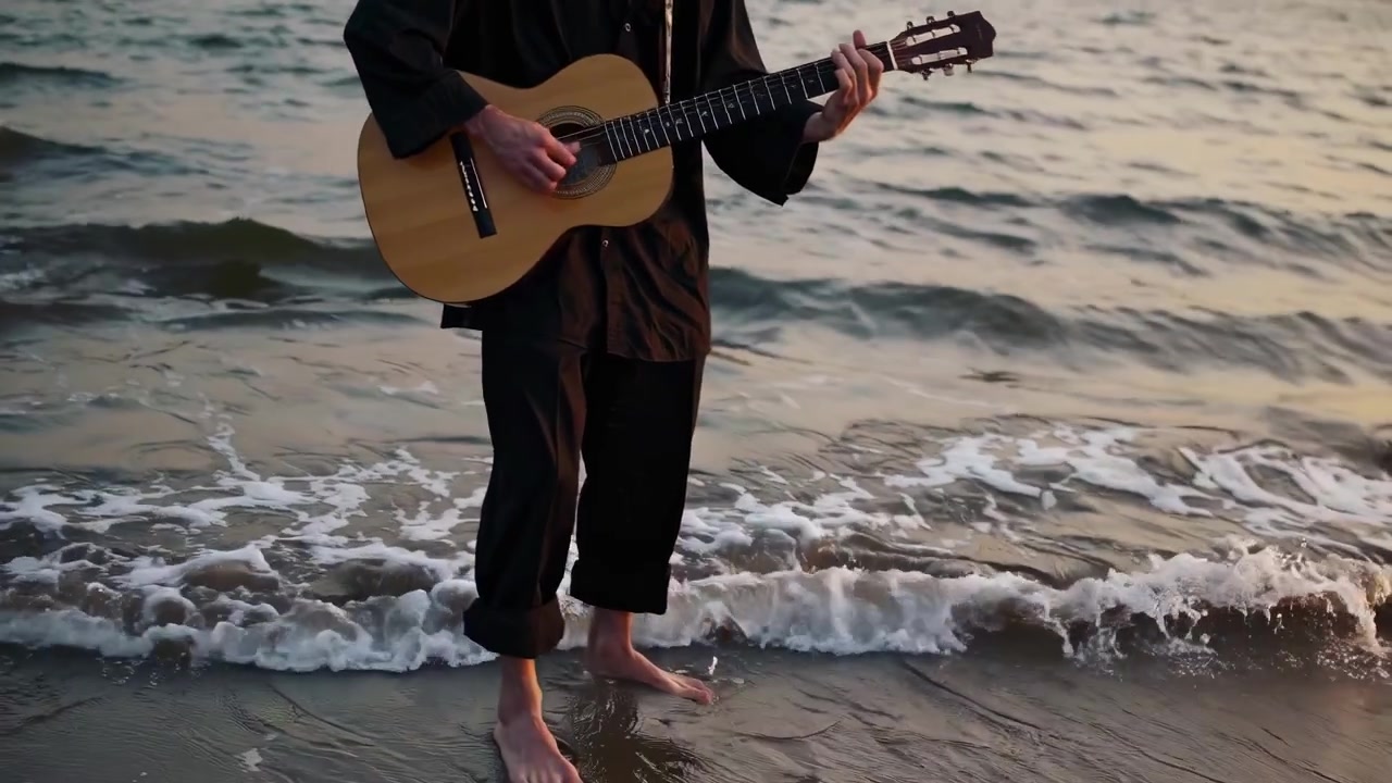 Joven tocando la guitarra acústica en la playa al atardecer