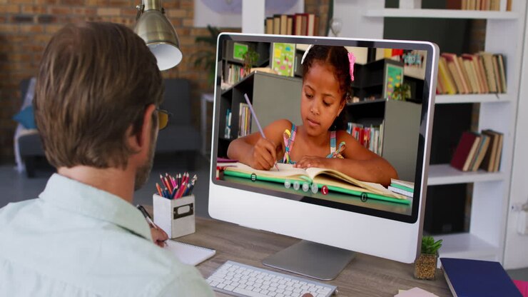 Profesor caucásico usando un ordenador en videollamada con una alumna.