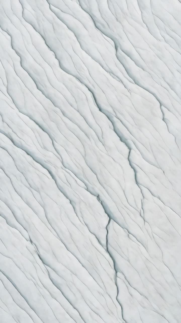 Abstract aerial view of snowy terrain with flowing lines. The top-down angle captures a serene