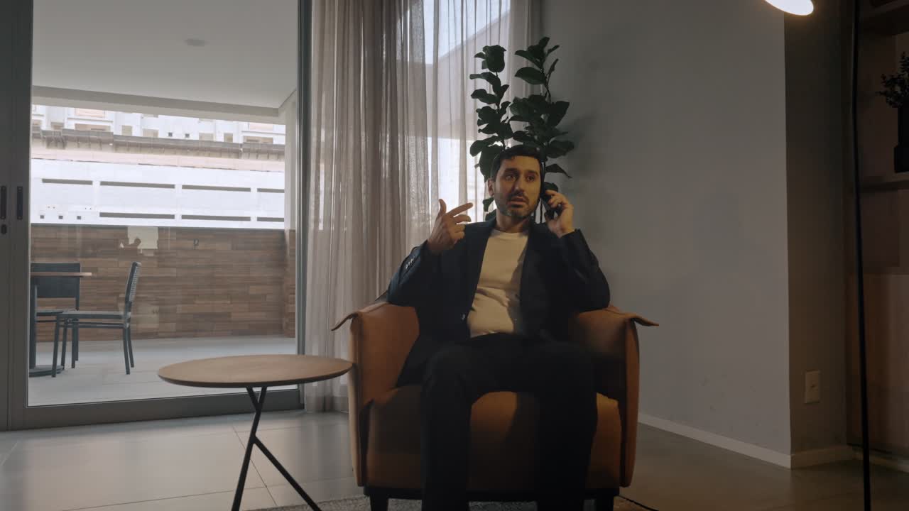 Executive man making a business call, seated comfortably in a modern office chair, with a cinematic semi orbit camera movement.