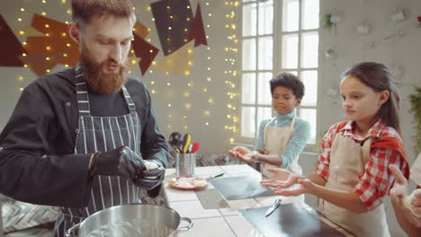 chef giving dough to children on cooking masterclass