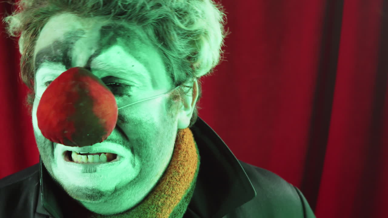 payaso triste fingiendo llorar en el escenario