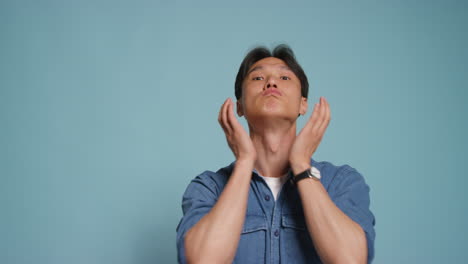 Man-In-Front-Of-Blue-Studio-Background-Posing-For-Photo-Booth-Style-Portraits