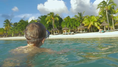 Zeitlupenansicht-Eines-Kleinen-Jungen,-Der-Mit-Der-Schnorchelmaske-Im-Indischen-Ozean-Schwimmt-Und-Ein-Foto-Von-Der-Insel-Port-Louis,-Mauritius-Macht