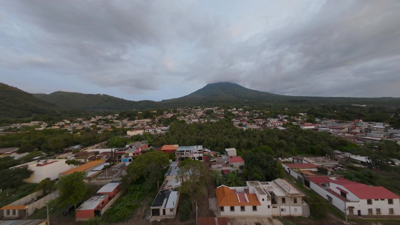 Vista aérea de un histórico pueblo de Antigua Guatemala con una gran montaña volcánica al fondo