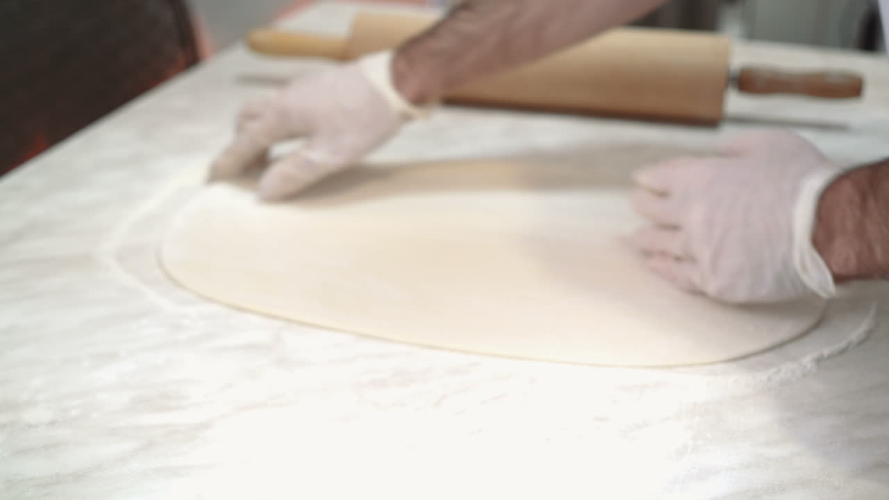 Impasto per pizza. Cuoco che prepara una deliziosa pizza al ristorante, primo piano.