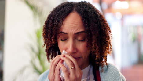 woman with cold or allergies sneezing into tissue
