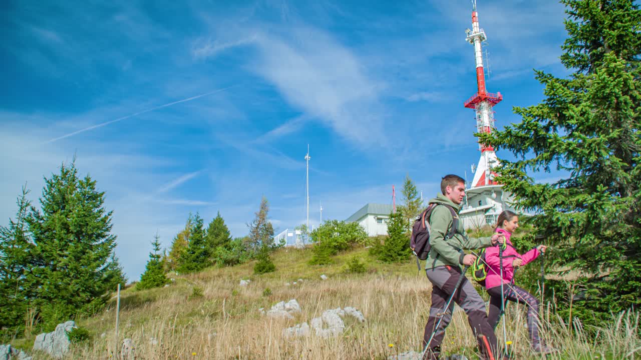 Adventurous couple trekking uphill at Mount St. Ursula in slow motion