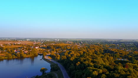 breath-taking cityscape full of greenery on bright sunny day. river flowing along the provincial city from top view.